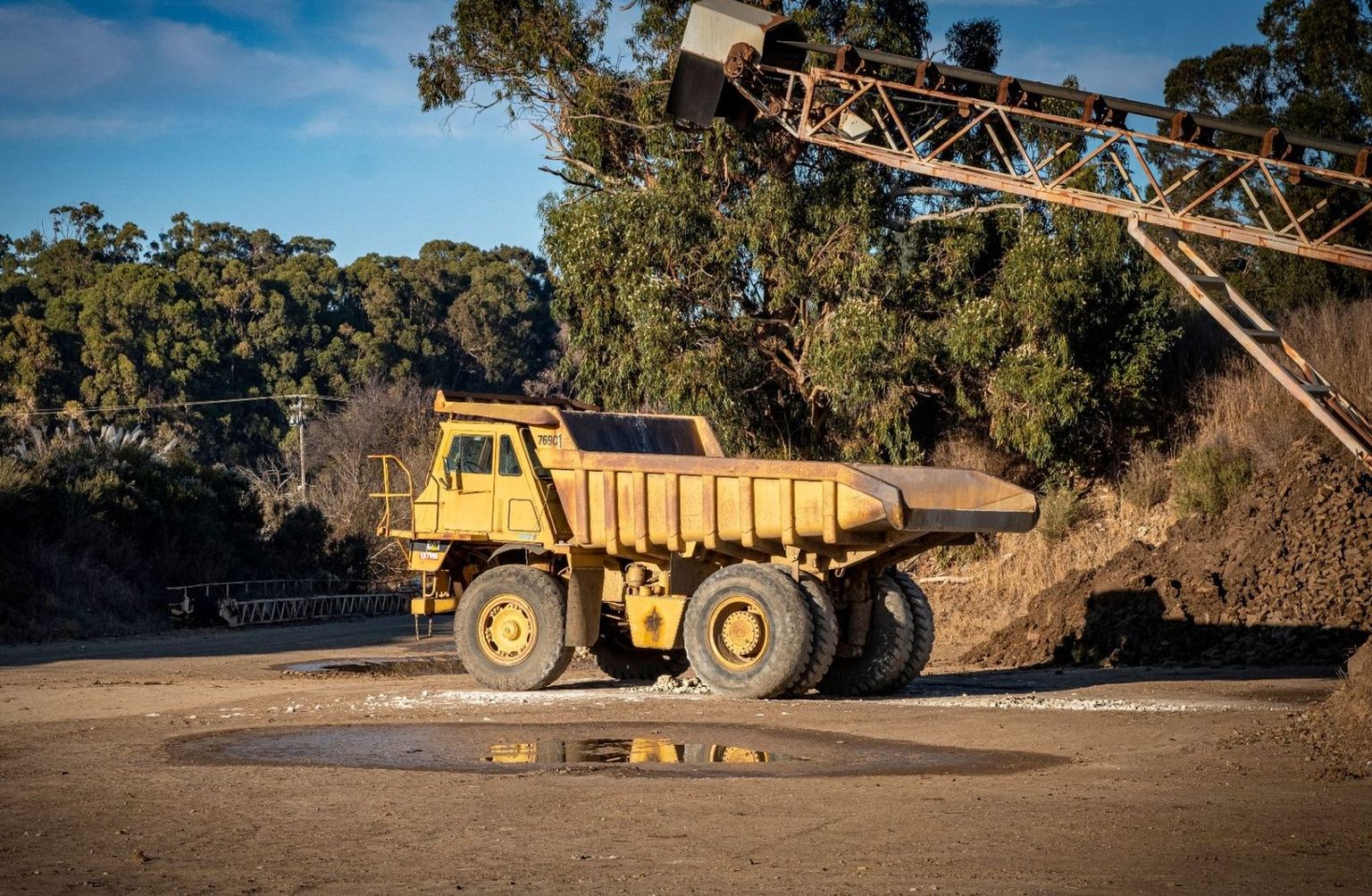 Mining contractor foreman checking a shift schedule on a rugged Android phone at an open-cut mine site — Connecteam alternatives for mining contractors
