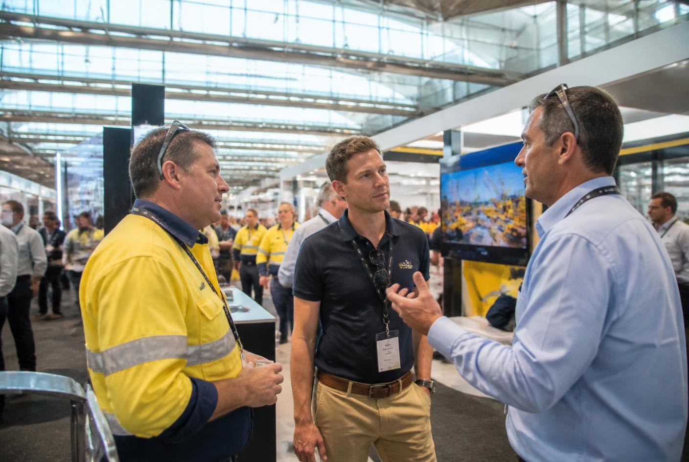 Mining contractors, supervisors and engineers talking at a mining industry expo in Perth